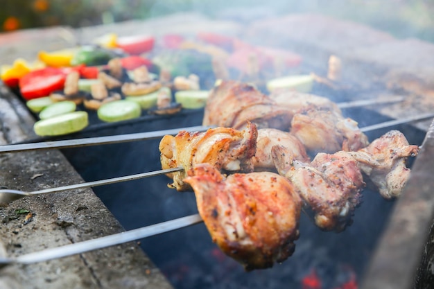 Verduras y carnes a la parrilla. Pimiento, tomate, champiñones y calabacín. Pollo a fuego abierto. Fiesta de barbacoa de verano. Alimentos naturales saludables.