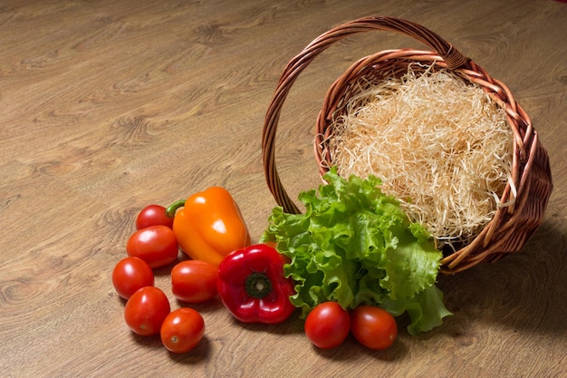 Verduras y cesta de madera sobre la mesa.