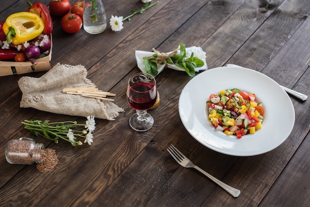 Verduras coloridas frescas en una placa blanca en un fondo de madera oscuro