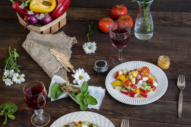 Verduras coloridas frescas en una placa blanca en un fondo de madera oscuro