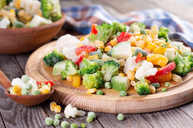 Verduras congeladas sobre tabla de madera en la mesa