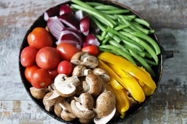 Verduras crudas de colores en una sartén