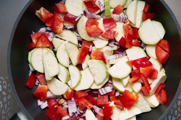 Verduras crudas multicolores preparadas para cocinar en una sartén