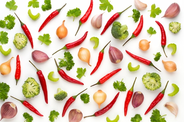 Verduras y especias aisladas sobre superficie blanca, vista superior. Papel tapiz de composición abstracta de verduras.