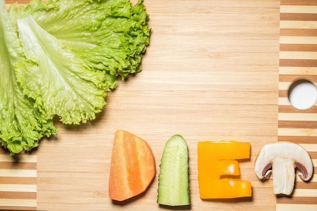 Verduras en forma de letras sobre una tabla para cortar