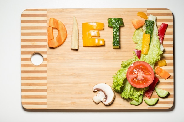 Verduras en forma de letras sobre una tabla para cortar