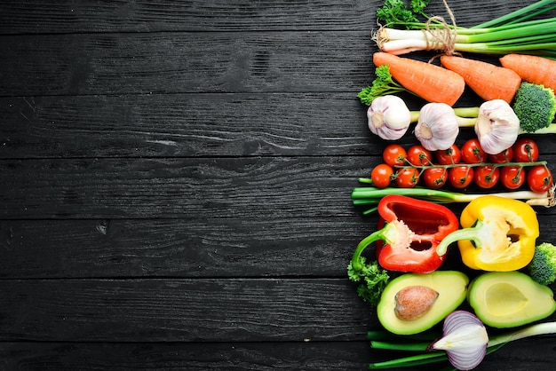 Verduras frescas Aguacate pepino cebolla ajo tomates zanahorias rábano picante Vista superior Espacio libre para el texto