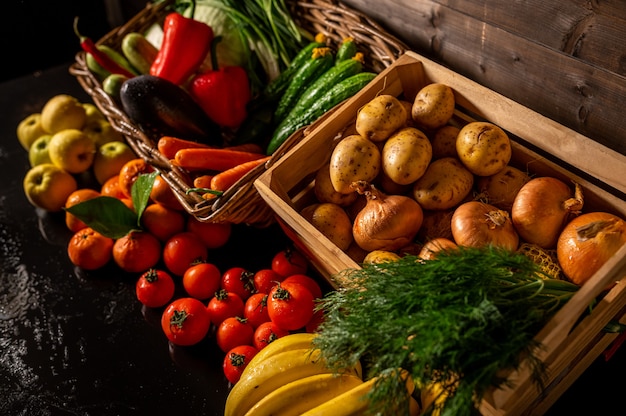 Verduras frescas en una caja de madera sobre un fondo de madera. Mercado de frutas y verduras