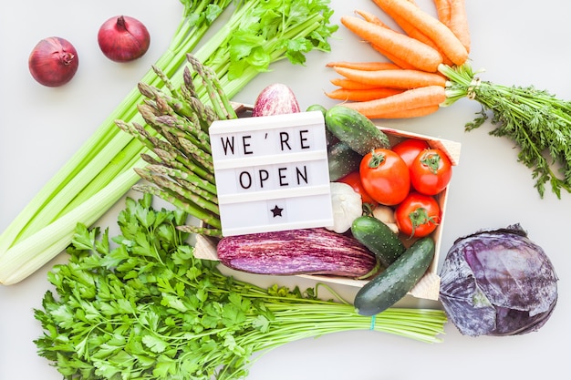 Verduras frescas en caja de madera con texto