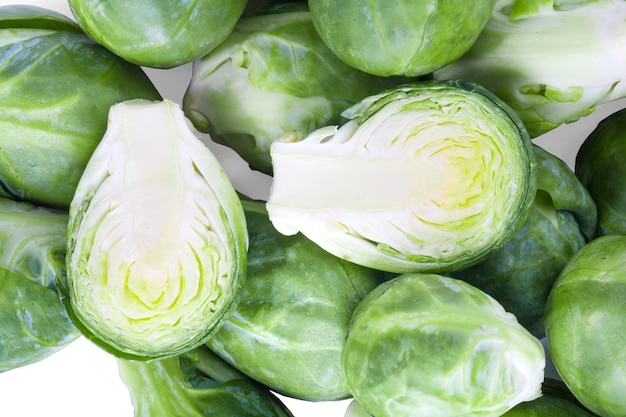 Verduras frescas coles de Bruselas verde sobre superficie blanca