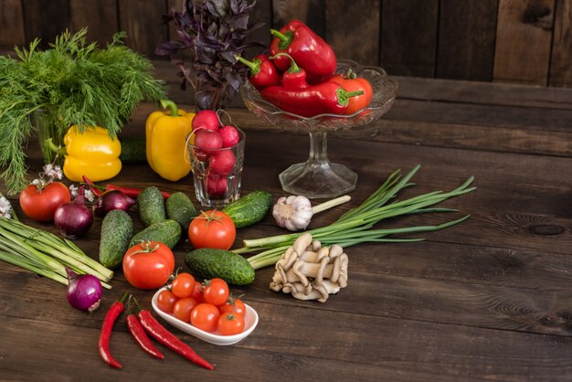 Verduras frescas de colores de un huerto en un fondo de madera oscuro