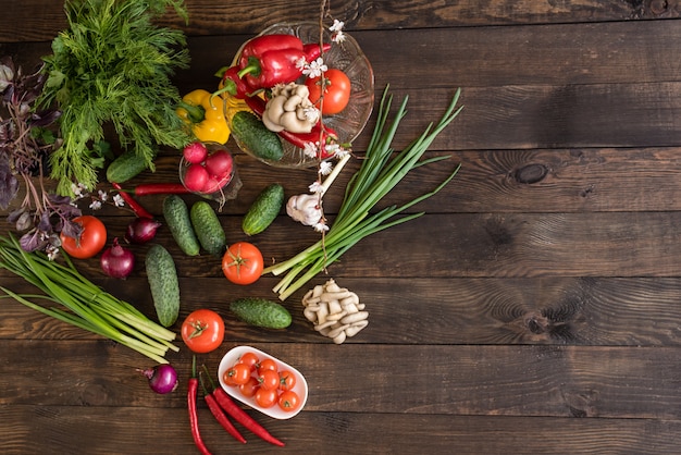 Verduras frescas de colores de un huerto en un fondo de madera oscuro