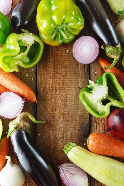 Foto verduras frescas e ingredientes para cocinar alrededor de una tabla de cortar vintage