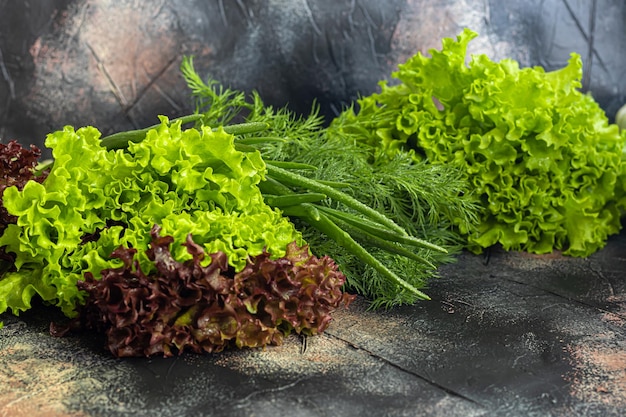 Verduras frescas para ensalada Tomates y lechuga pepinos con calabacín y repollo con eneldo Beneficios de la cosecha de primavera y vitaminas En un espacio de copia de fondo oscuro