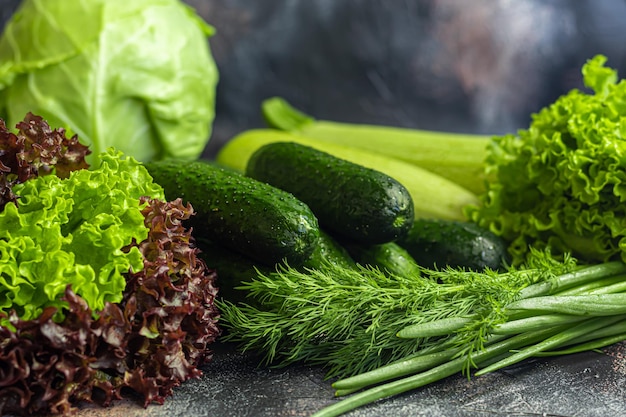 Verduras frescas para ensalada Tomates y lechuga pepinos con calabacín y repollo con eneldo Beneficios de la cosecha de primavera y vitaminas Sobre un fondo oscuro