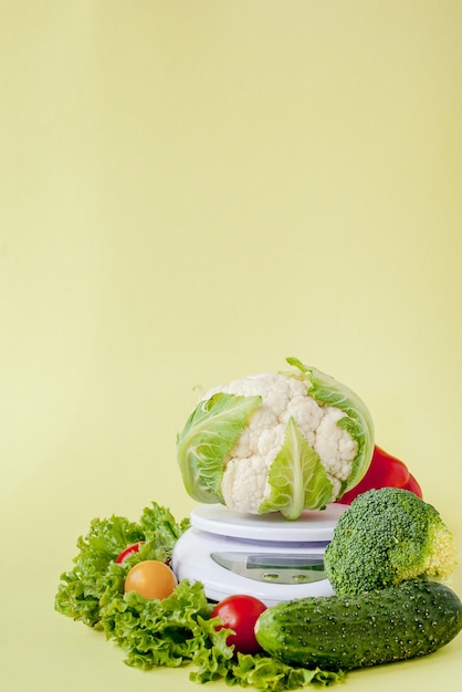 Verduras frescas en florero sobre fondo amarillo. Alimentación saludable, planificación de la dieta, pérdida de peso, desintoxicación, concepto de agricultura orgánica.