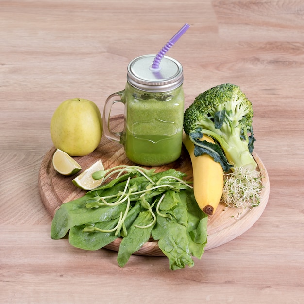 Verduras frescas, frutas y batido verde en tarro