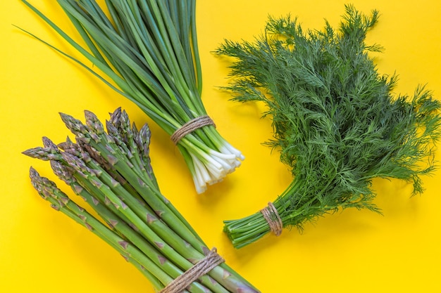 Foto verduras frescas y jugosas del banco ecológico. espárragos, cebollas verdes y eneldo. dieta saludable