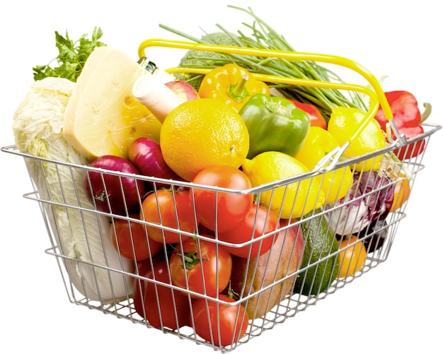 Verduras frescas maduras en la cesta de la compra sobre fondo blanco.