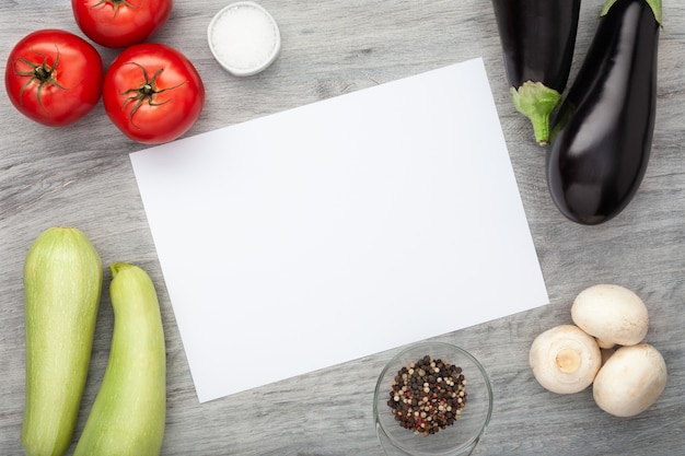 Verduras frescas en mesa de madera con papel blanco