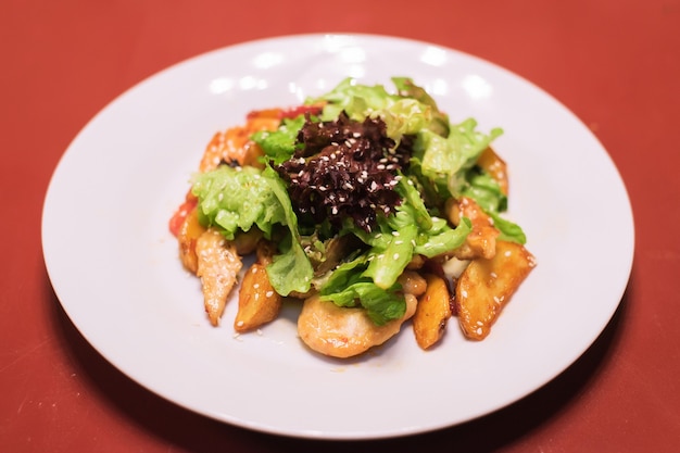 Verduras frescas patatas huevos ensalada de semillas de sésamo ensalada de hojas en una placa blanca.