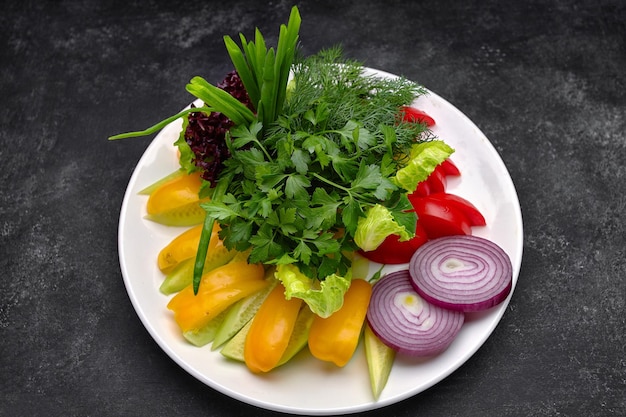 Verduras frescas picadas y hierbas en un plato Cerrar