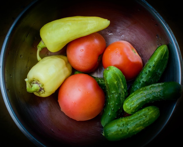 Verduras frescas en una placa de metal. Pepinos, tomates y pimientos frescos.