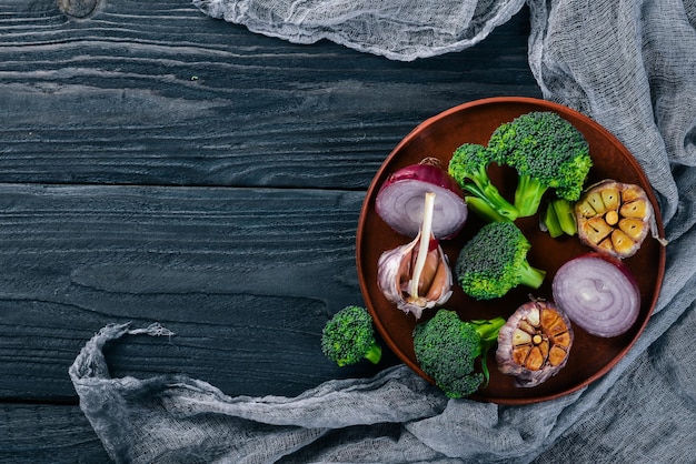 Verduras frescas en un plato de arcilla Sobre un fondo de madera Vista superior Espacio libre para su texto