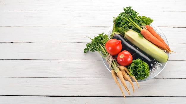 Verduras frescas en un plato Comida orgánica Sobre un fondo de madera Vista superior Espacio de copia