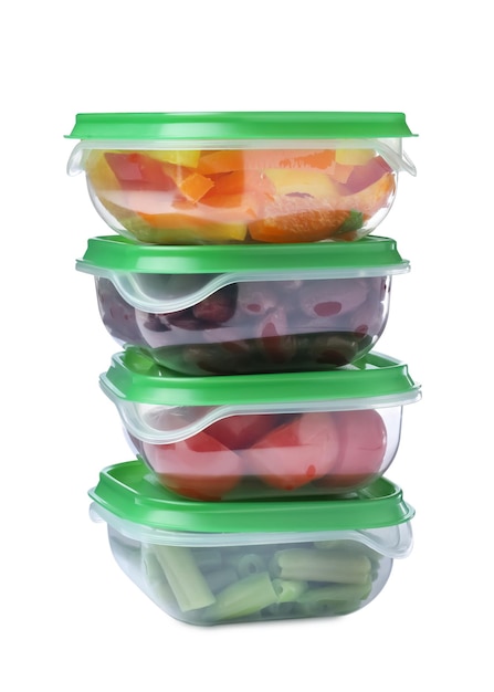 Verduras frescas en recipientes de plástico sobre fondo blanco.
