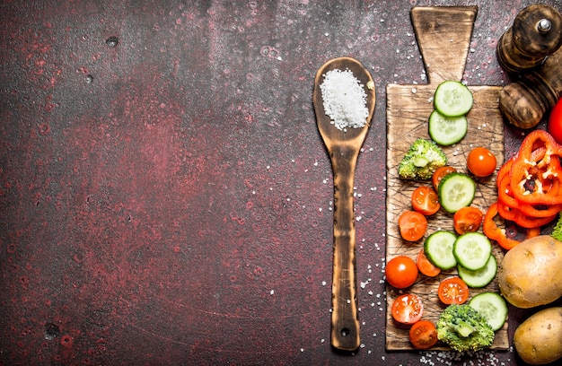 Verduras frescas en rodajas en el tablero antiguo