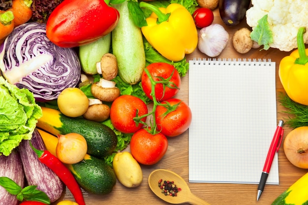 Verduras frescas sobre fondo de madera y cuaderno