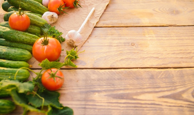 Verduras frescas sobre un fondo de madera Espacio vacío para el texto Pepinos tomates ajo eneldo Vista superior