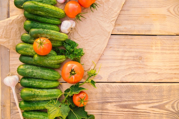 Verduras frescas sobre un fondo de madera Espacio vacío para el texto Pepinos tomates ajo eneldo Vista superior