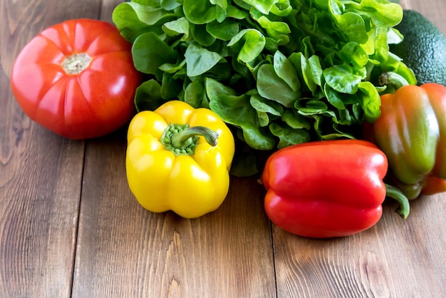 Verduras frescas sobre fondo de madera Hermosos pimientos crudos amarillos y rojos Comida para los días de ayuno