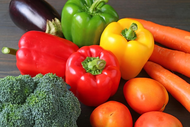 Verduras frescas variadas y coloridas sobre fondo de madera negra para el concepto de BIENESTAR