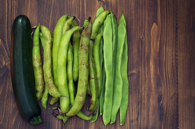 Verduras frescas verdes sobre superficie de madera marrón