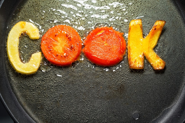 Verduras fritas en forma de letras en una sartén en aceite