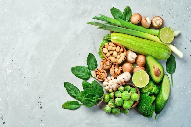 Verduras y frutas aguacate brócoli verde nueces champiñones bayas y manzanas verdes quinoa Alimentos saludables Sobre un fondo de piedra gris Vista superior