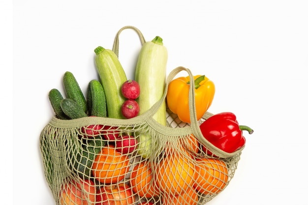 Verduras y frutas en una bolsa de cadena sobre un fondo blanco aislado. El concepto de compras ecológicas y buena nutrición. Entrega de productos.