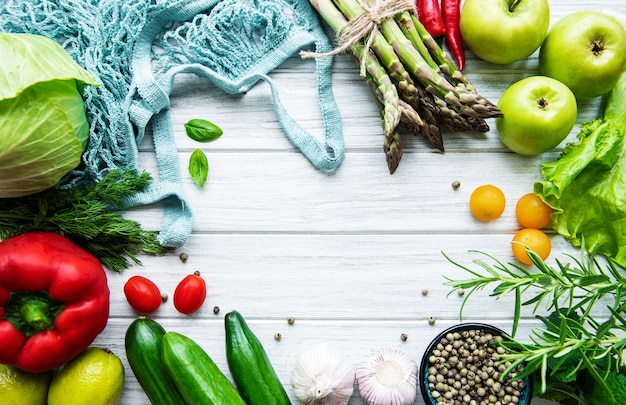 Verduras y frutas frescas con una bolsa de hilo sobre una superficie de madera blanca. Estilo de vida saludable. Vista superior. Cero desperdicio.