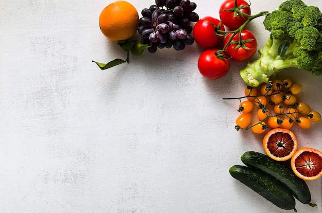 Verduras y frutas frescas en una mesa de cocina blanca. Fondo para supermercados, tiendas de alimentos frescos, entrega.