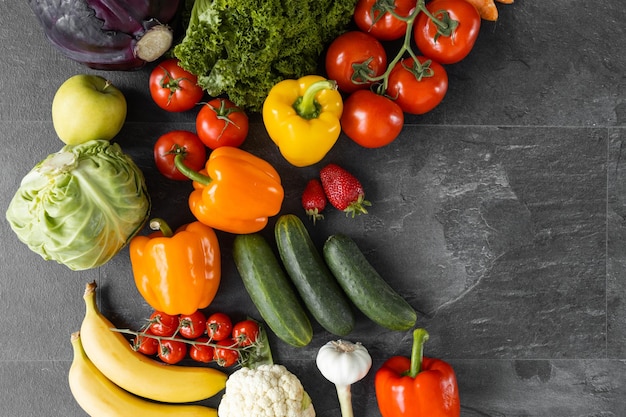 Verduras y frutas frescas sobre un fondo negro Alimentos orgánicos Vista superior Espacio de copia libre