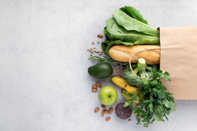 Verduras, frutas, pan en una bolsa de papel en gris