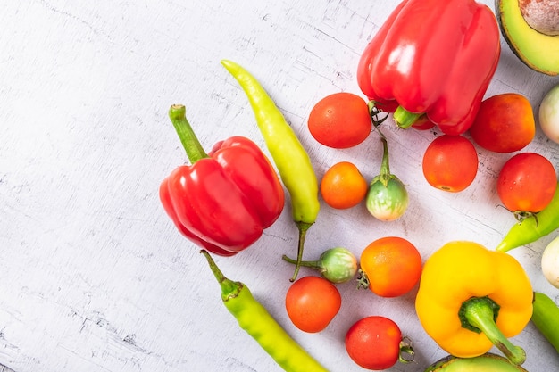 Verduras y frutas sobre un fondo blanco de madera.