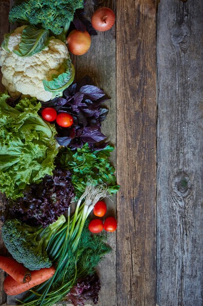 Verduras y hierbas frescas sobre una vieja superficie de madera rugosa