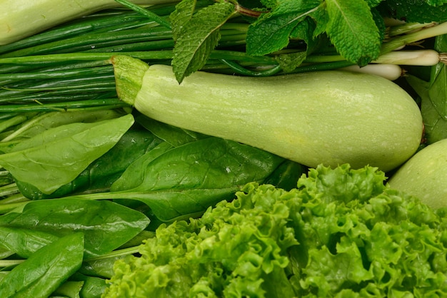 Verduras y hierbas verdes frescas como fondo.