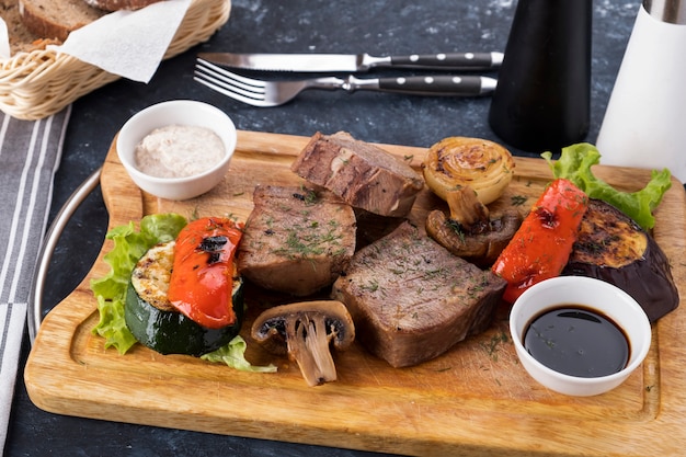 Verduras de lengua de ternera a la plancha sobre tabla de madera