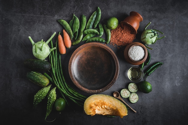 Verduras en una mesa negra con espacio para un mensaje en el medio