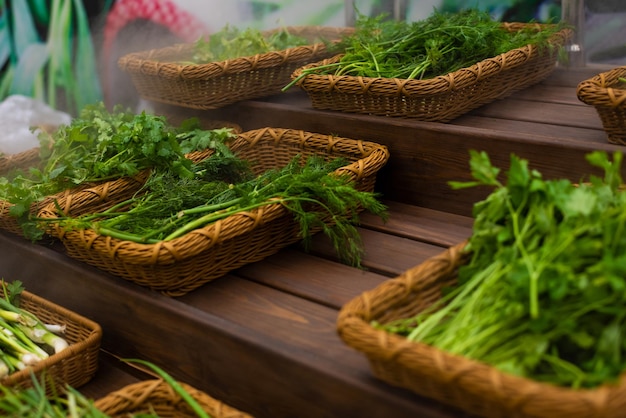 Foto verduras en el mostrador de la tiendaeneldo y perejil sobre una mesa de madera soplada con vapor hidratante